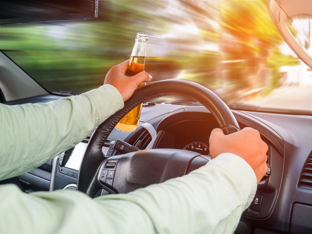 Driver holding an alcohol bottle while driving a vehicle in Florida