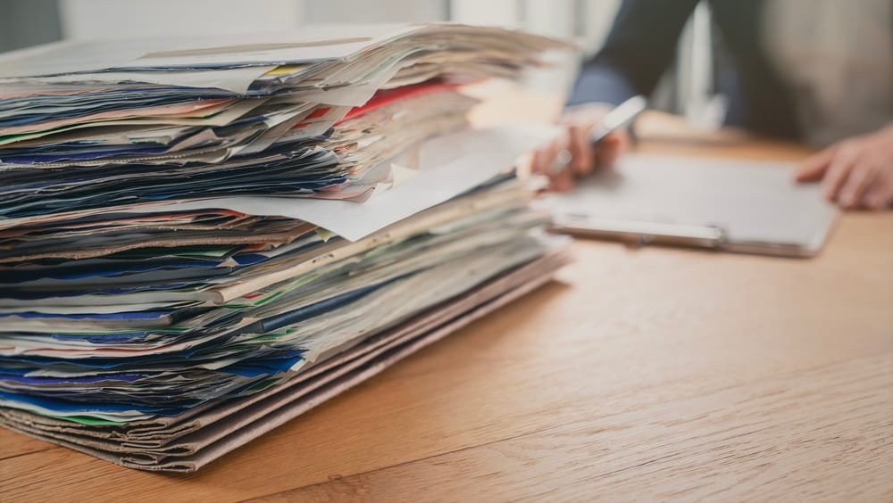 Large stack of legal documents on a desk related to a drunk driving accident claim in Coral Springs FL