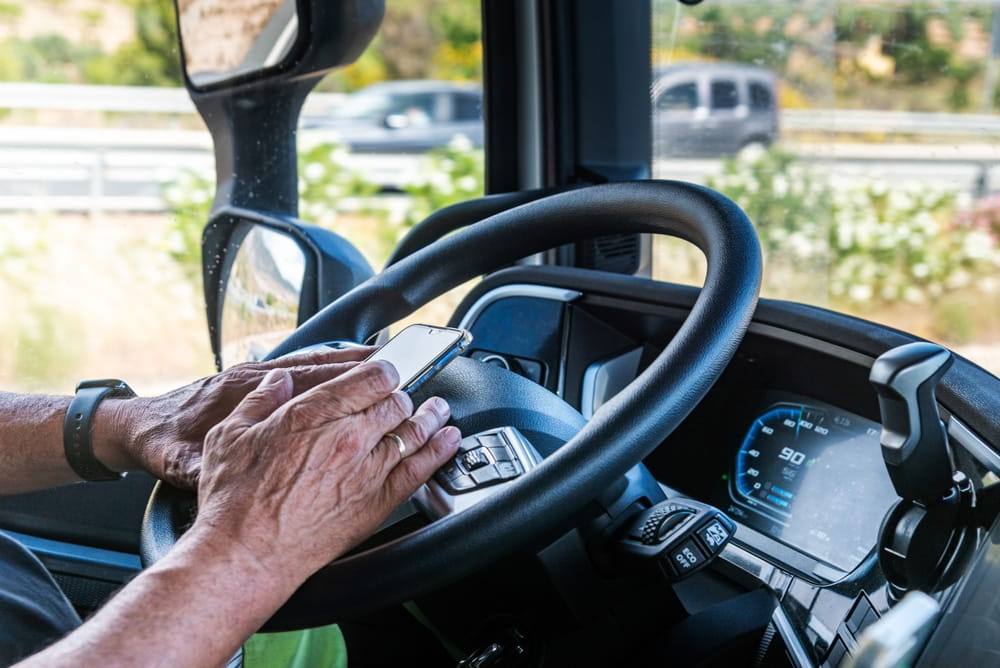 Driver holding a phone while gripping the steering wheel